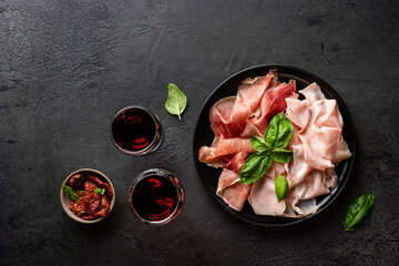 Appetizers with differents antipasti, charcuterie, snacks and red wine. Sausage, ham, tapas, olives and crackers for buffet party. Top view, flat lay