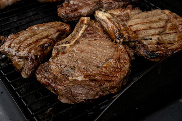 Steaks cooing over a flame grill, ready to be served. Shot shallow depth of field. 