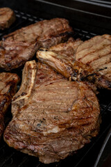 Steaks cooing over a flame grill, ready to be served. Shot shallow depth of field. 