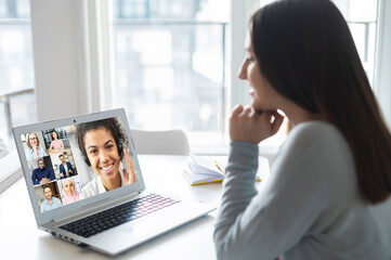 Female employee involved video meeting on the laptop with work team, woman using computer app for video connect with diverse colleagues, brainstorming online, discussion during video meeting