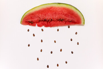 a piece of watermelon with seeds creative image in the form of an umbrella and raindrops