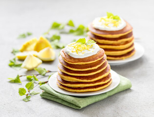 Lemon pancakes on a plate on a light gray background