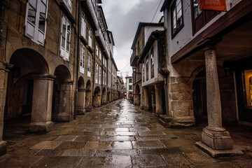 Santiago de Compostela - October 2018: Narrow street with porticoes in Santiago de Compostela on a rainy day