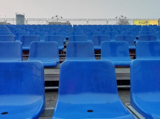 Naklejka premium Seats at the stadium. shallow depth of field. Empty blue seats in a row at the sport stadium. 