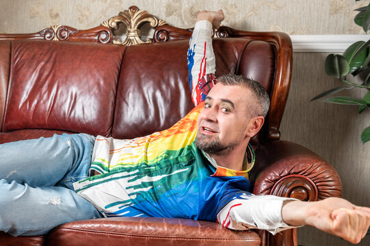 Gay stretching on his couch. Happy man yawns and stretches on comfortable sofa.