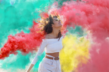 Beautiful young woman surrounded  light up colored smoke bombs - Happy friends having fun in the...