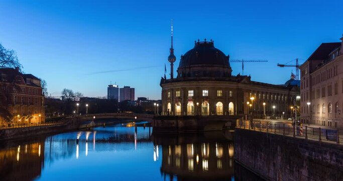 Night to day hyperlapse of Berlin city skyline, movement along waterfront with TV Tower, spree river and historic museum in frame, 4k