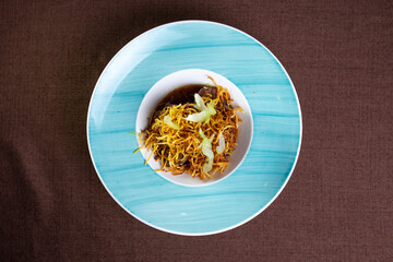 potato pai with meat and sauce on a blue plate top view.