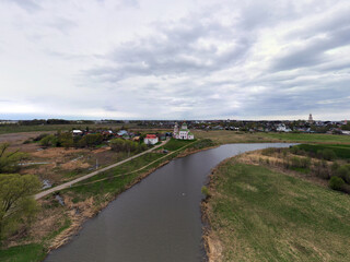 Fototapeta premium a panoramic view of the historical center of the temples and monasteries of the city of Suzdal in the rain filmed from a drone 