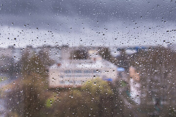 Rain drops on a window.  Street, city behind glass