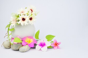 Pink flower shaped candles and vases on flowers on white background