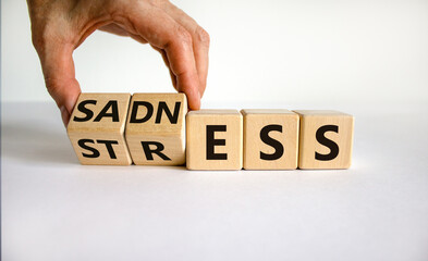 Sadness and stress symbol. Doctor turns cubes and changes the word 'stress' to 'sadness'. Beautiful white table, white background. Medical, psychological and sadness to stress concept. Copy space.