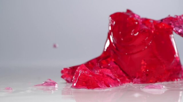 Falling jelly on white wet surface in slow motion.