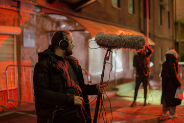 Sound engineer with a microphone on the set. A professional sound engineer at work on the filming of a movie