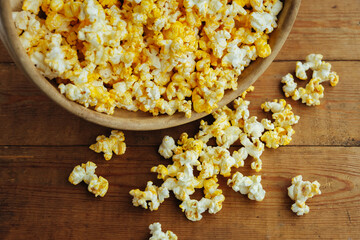 Salty cheese popcorn on a wooden background. Close-up.