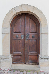 old wooden door, finished with metal decorations in the historic part of the German town of Mainz