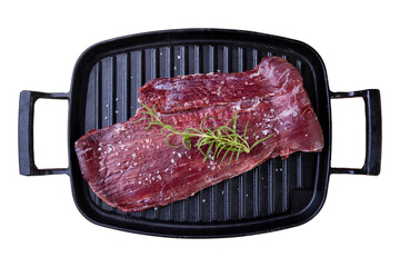 raw meat in cast iron plate with rosemary branch on white background