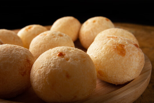 Brazilian Cheese bread, cheese breads arranged on wooden plate, on rustic wood, selective focus.