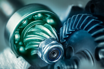 Artistic detail of steel gear wheels inside angle grinder machine in green blue shade. Mechanism of...
