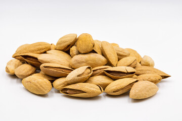 bunch of inshell almonds closeup against white