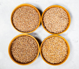 various hulled wheat grains in round ceramic bowls
