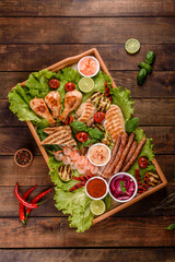 Composition of sausages, chicken, pork and shrimp prepared on grill, as well as vegetables prepared on grill with spices and herbs