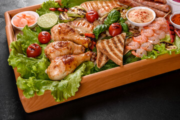 Composition of sausages, chicken, pork and shrimp prepared on grill, as well as vegetables prepared on grill with spices and herbs