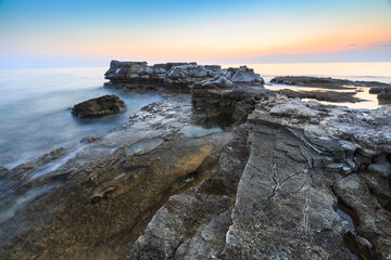 Enjoying the colorful sunset on a beach with rocks on the Adriatic Sea coast Istria Croatia