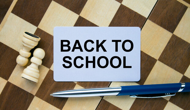 Business card with text Back To School on a chess board with pen and eyeglasses