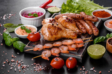 Composition of sausages, chicken, pork and shrimp prepared on grill, as well as vegetables prepared on grill with spices and herbs