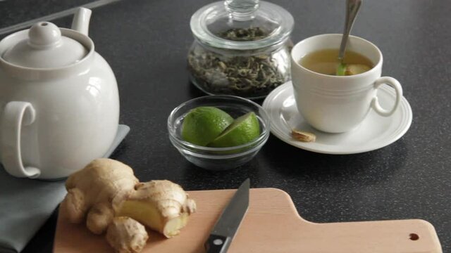 Making green tea for breakfast with lime and ginger at the kitchen