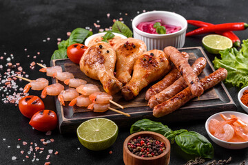 Composition of sausages, chicken, pork and shrimp prepared on grill, as well as vegetables prepared on grill with spices and herbs