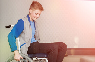teen boy student sitting in a wheelchair at home.