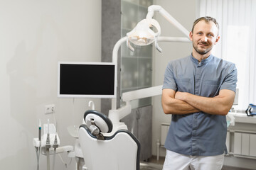 Obraz premium Portrait of a friendly male dentist in his office. Modern dental clinic.
