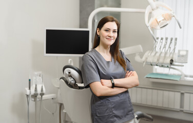 Fototapeta na wymiar Portrait of a friendly female dentist in her office. Modern dental clinic.