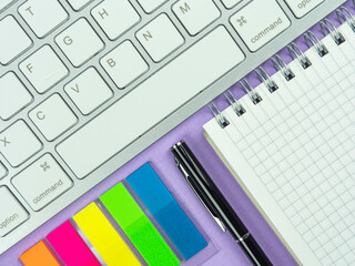 Top view above of purple desk table with keyboard, and paper. Workplace, Flat lay. Office work conception.