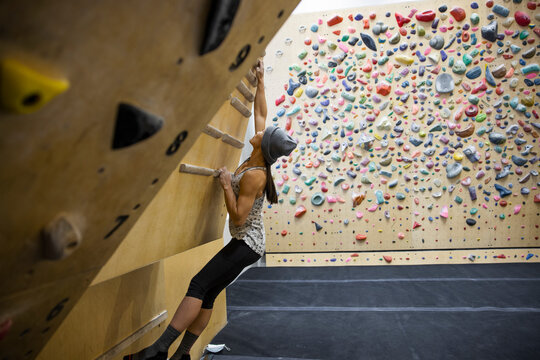 Athletic young woman hang boarding in climbing gym