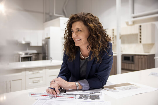 Portrait Of Interior Designer With Sketch Plan In Kitchen Showroom