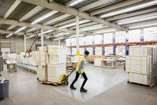 Worker moving cargoes in distribution warehouse