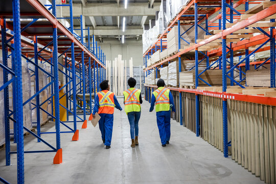 Rear view of workers walking together in distribution warehouse