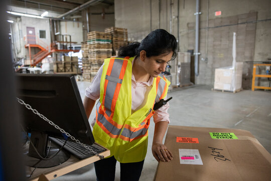 Supervisor checking cardboard box in distribution warehouse