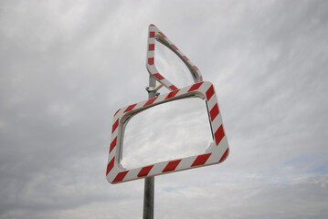 zwei Spiegel  in verschiedenen Richtungen vor bewölkten Himmel. Symbol für Sichtweise 