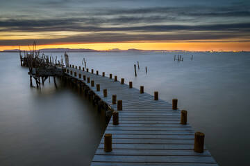 Sunset at Carrasqueira Pier. Located in the small Carrasqueira village in Alentejo, Portugal. His port of artisanal fishing was hand built with wooden pegs.