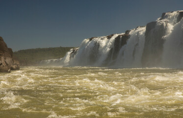 Navigating the rapids. The majestic Mocona falls seen from the boat. The rocky waterfall white water, strong river current flowing across the jungle.