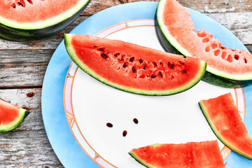 Slices of ripe fresh watermelon on wooden table outdoor. Healthy eating summertime concept. Organic fruits.