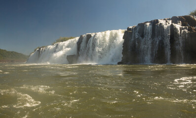 Navigating the rapids. The majestic Mocona falls seen from the boat. The rocky waterfall white water, strong river current flowing across the jungle.