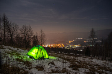 Yellow tent in winter forest at night