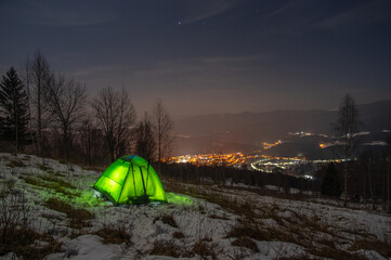 Fototapeta na wymiar Yellow tent in winter forest at night