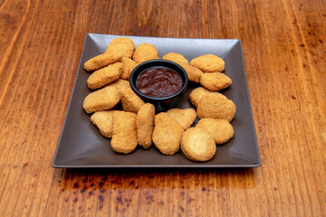 Square black plate with a large portion of well-fried nuggets