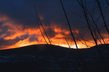 Amanecer dorado invernal con unas colinas llenas de nieve